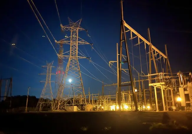 A night time photo of power lines and towers.