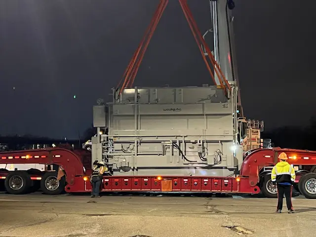 A large crane lifting a red truck.